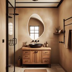 a bathroom with a round mirror above the sink and wooden cabinetry on the side