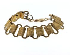 This beautiful antique piece came to us with no connecting ends. Maybe it was a bracelet or maybe it was a watch fob. We added a brand new 14k gold filled lobster claw and loop on the other end to make a lovely 7 inch bracelet. On each link is a varying scene of hand engraved detail featuring scroll work and orange blossoms common to this time period. The bracelet is comfortable to wear and would look great layered with other vintage bracelets.Condition: Very good vintage conditionSize: .6 inche Antique Gold Brass Bracelets For Formal Occasions, Formal Antique Gold Brass Bracelets, Formal Antique Gold Brass Bracelet, Antique Gold Bracelet Strap Jewelry, Antique Yellow Gold Brass Bracelets, Antique Gold Rectangular Bracelet, Formal Metal Bracelets With Antique Finish, Formal Gold Bracelets With Antique Finish, Formal Engraved Brass Bracelets