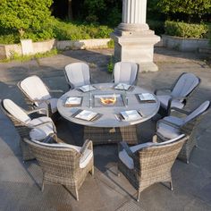 an outdoor table with chairs and plates on it in the middle of a patio area