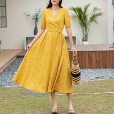 "The dress in the image is a captivating ensemble, perfect for a sunny day out. It's a mid-length, bright yellow dress that exudes cheerfulness with its small floral patterns. The short sleeves and wrap-around design tie at the waist, accentuating the figure, while the V-neckline adds a touch of sophistication. Paired with a straw hat and open-toed sandals, it's an outfit that balances casual comfort with chic style.  DETAILS * 50% linen, 50% cotton blend * Cotton lining on upper part, more comf Short Sleeve Floral Print Midi Dress For Summer, Mid-length Floral Dress For Summer, Elegant Yellow Floral Summer Dress, Spring Midi Sundress For Brunch, Floral Print Summer Maxi Dress, Elegant Short Sleeve Sundress For Summer, Knee-length Floral Sundress For Summer, Spring Embroidered Midi Dress, Spring A-line Midi Dress For Day Out