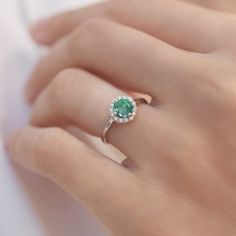 Even the legendary Queen Cleopatra ornamented herself with Emerald. Emerald jewels are traditional presents for 20th and 35th wedding anniversaries, but magical green beauty is great engagement piece too. This ring is crafted at our atelier in white gold with a halo of diamonds. #klenota #klenotajewelry #whitegold #14k #14carat #symboloflove #finejewelry #specialoccasion #jewelrymakers #klenotaring #ring #diamond #emerald #haloring #gemstonering #engagement #anniversarygift Formal Diamond Ring With Halo For May Birthstone, Diamond White Emerald Ring With Halo Setting For Anniversary, Green Emerald Ring With Halo Round Cut, Emerald Birthstone Ring With Brilliant Cut, Anniversary Emerald Ring With Diamond White Halo Setting, Round Emerald Birthstone Ring With Brilliant Cut, May Birthstone Round Brilliant Cut Diamond Ring, Round Diamond Ring For May Birthstone, Formal May Birthstone Diamond Ring With Halo Design