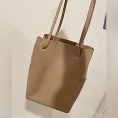 Beige Cream Color. With Two Side Pockets. 9” L X 5 1/4” W X 12 3/4” H Cream Bucket Satchel For Everyday, Everyday Cream Bucket Satchel, Neutral Rectangular Shoulder Bag For Daily Use, Cream Rectangular Bucket Bag For Everyday Use, Versatile Beige Soft Leather Bucket Bag, Everyday Beige Rectangular Bucket Bag, Light Brown Rectangular Bag For Everyday Use, Beige Soft Leather Bucket Bag For Everyday Use, Everyday Beige Soft Leather Bucket Bag