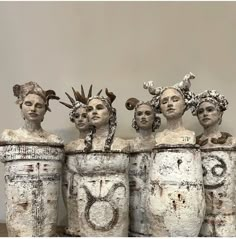 five white vases with faces and hair on them