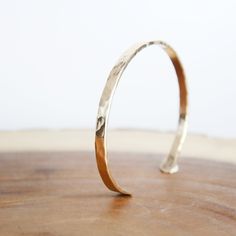 Hammered Cuff Gold-Fill Our Hammered Gold Cuff Bracelet captures the essence of the sun's radiance. As you wear the Hammered Gold Cuff Bracelet, let it be a reminder of your own luminance and strength. Much like the sun's steadfast presence, this piece accompanies you through every adventure and journey, infusing your spirit with its golden energy. 2.5mm Thick x 6" long Gold-Fill Wire (8G) Hand-Forged & hand textured Gold Filled is NOT the same as gold plated. Gold fill is much higher quality th Minimalist Adjustable Hammered Cuff Bracelet, Adjustable Open Band Bracelet For Gift, Adjustable Open Band Bracelet As Gift, Adjustable Hammered Cuff Bangle, Hammered Adjustable Cuff Bracelet Gift, Adjustable Hammered Cuff Bracelet Gift, Adjustable Hammered Cuff Bracelet As Gift, Adjustable Open Band Bangle As A Gift, Adjustable Hammered Cuff Bracelet