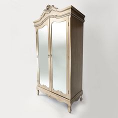 an antique armoire with mirrored doors on the front and bottom, against a white background