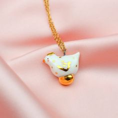 This hen with golden egg necklace will make a cute gift for your special someone. The hen is made out of quality porcelain glazed with transparent glaze and embellished with gold. Comes with a 60 cm long golden stainless steel chain. Product Info: Charm: 2.1 x 1.7 cm (0.82 x 0.66 in) - Size varies a bit from bead to bead. Necklace: 60 cm (23.62 in) Comes in a nice-looking box, ready to be gifted Other ceramic jewelry, ceramic earrings and necklaces are available in my etsy shop: www.etsy.com/uk/ Whimsical Personalized Gold Necklace, Handmade White Charm Necklaces For Birthday Gift, Handmade Gold Necklace For Birthdays, Whimsical White Necklaces For Gifts, Whimsical White Necklace For Gift, Handmade Yellow Gold Necklaces For Birthdays, Whimsical White Necklace Perfect For Gifts, Whimsical Gold Jewelry For Mother's Day, Personalized Jewelry For Easter Gifts