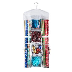 the hanging storage bag is filled with wrapping and christmas decorations, including balls, gifts, and other items