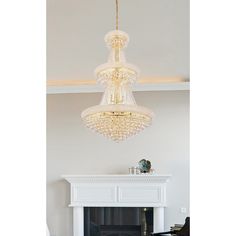 a chandelier hanging from the ceiling over a fireplace in a room with white walls