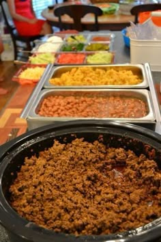 several trays of food sitting on top of a table