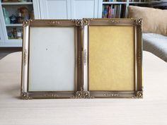 two gold frames sitting on top of a table