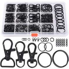 an assortment of various black and white objects in a plastic container with clippers, hooks, eyelets, and clips