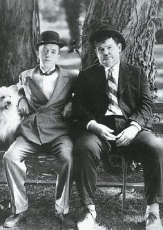 black and white photograph of two men sitting on a chair in front of bookshelves