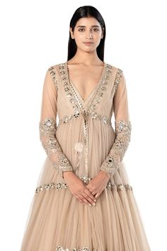 Beige long tiered jacket with mirror embroidery. Comes with sleeveless anarkali with mirror embroidered hem.
Components: 2
Pattern: Embroidered
Type Of Work: Mirror
Neckline: Plunged V
Sleeve Type: Jacket: Long, Anarkali: Sleeveless
Fabric: Anarkali- Organza, Jacket- Net
Color: Beige
Other Details: 
Back tassel tie anarkali
Front tie-up jacket
Occasion: Destination Wedding - Aza Fashions Long Sleeve Lehenga With Gota Work For Eid, Transitional Bandhgala With Gota Work And Long Sleeves, Transitional Long Sleeve Bandhgala With Gota Work, Long Sleeve Gota Work Choli For Eid, Long Sleeve Choli With Gota Work For Eid, Anarkali Bandhgala With Gota Work For Festive Season, Anarkali Long Sleeve Choli With Cutdana, Elegant Long Sleeve Lehenga With Gota Work, Anarkali Bandhgala With Gota Work For Eid