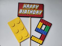 a lego cake topper with the number nine on it and a happy birthday sign