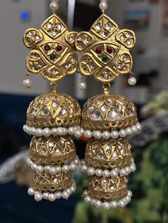 Add a touch of elegance and cultural charm to your jewelry collection with these stunning traditional jhumka earrings. These earrings are a beautiful representation of Indian and Pakistani craftsmanship, featuring intricate gold-plated work adorned with dazzling Kundan stones and delicate pearl detailing. Perfect for weddings, festivals, and special occasions, these earrings are designed to make you stand out with their timeless beauty. Features: Intricate Design: These jhumka earrings showcase a beautiful traditional design with a detailed pattern that reflects the rich cultural heritage of South Asia. High-Quality Materials: Made from high-quality gold-plated alloy, these earrings are designed to offer a luxurious feel while being durable for long-lasting wear. Kundan and Pearl Embellish Traditional Jhumka, Beauty Features, Faux Pearl Earrings, Jhumka Earrings, South Asia, Traditional Indian, Cultural Heritage, Intricate Design, Traditional Design