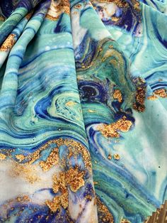 blue and gold marbled fabric laying on top of each other