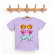 Looking for a cute tee for your kids? We have the perfect Sunnies Summer Vibes graphic tee addition to their closet! Also available in toddler tees. Casual Spring T-shirt With Cute Design, Spring Purple T-shirt With Graphic Print, Fun Purple T-shirt With Funny Print, Casual Purple T-shirt With Cartoon Print, Summer Character Print Tops For Playwear, Playful Summer T-shirt With Character Print, Casual T-shirt With Cute Design For Spring, Casual Summer T-shirt With Cute Design, Casual Cute Summer T-shirt