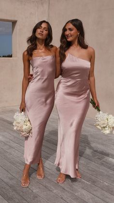 two women standing next to each other in dresses