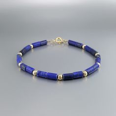 "Matte Lapis Lazuli bracelet with 14K gold plated beads and clasp. Unique gift for her or him, girlfriend, wife, September and December birthstone, 9 year anniversary. Beautiful bracelet with matte Lapis Lazuli tubes and Sterling silver 14K gold plated beads. The stones are arranged 2 to 1 with the metal parts. The stones are strung on stainless steel and finished with a Sterling silver 14K gold plated clasp. All our stones are natural stones and our jewelry handmade, slight differences in color Gold Lapis Lazuli Bracelets For Gift, Gold Bracelets With Lapis Lazuli And Natural Stones, Elegant Lapis Lazuli Bracelets For Gifts, Gold Lapis Lazuli Bracelet With Gemstone, Gold Lapis Lazuli Gemstone Bracelet, Handmade Gold Beaded Lapis Lazuli Bracelets, 9 Year Anniversary, Lapis Lazuli Bracelet, Unique Gifts For Her