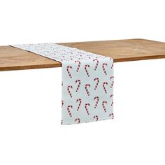 a wooden table topped with a white and red candy cane runner