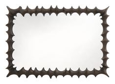 a rectangular mirror with spikes on the edges and a white back drop in the middle