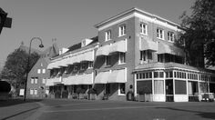 a black and white photo of an apartment building on the corner of a city street