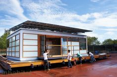 some people are standing on the back of a houseboat that's being built