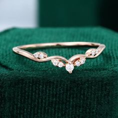 a diamond ring sitting on top of a green velvet bag