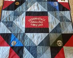 a quilt with patches on it is laying on the floor in front of a wall