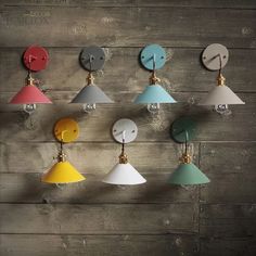 several different colored lights hanging on a wooden wall