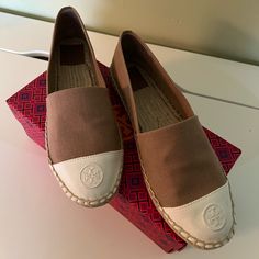 Timeless Shoes For Summer! Tan And White Colorblock Canvas Material With Embossed Tory Burch Logo On The Toe. Stacked Jute Sole, Very Comfortable! Size 10.5 Brand New In The Box, Never Worn Retails For $228 Brown Slip-on Espadrilles With Contrast Sole, Spring Brown Espadrilles With Contrast Sole, Brown Flat Espadrilles With Cushioned Footbed, Flat Espadrilles With Removable Insole, Tory Burch Espadrilles, Shoes For Summer, Summer Tan, Timeless Shoes, Espadrille Shoes