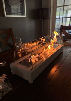 a fire pit sitting on top of a wooden table next to a wine glass holder