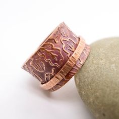 Discover the essence of Minimalist style with our exquisite Handmade Copper Band Ring, adorned with doodle style Oak patterns, a perfect gift for Botanical Lovers. The meditation spinner is crafted from Hammered copper wire featuring a soothing matte finish. The Copper band, transformed into a warm earthy brown through oxidation, boasts gracefully flared edges, allowing unrestricted movement and effortless spinning of the silver spinner ring.  Elevate your style and inner peace with this unique Doodle Style, Earthy Brown, Red Copper, Silver Spinner Rings, Copper Ring, Oak Leaves, Jewelry Studio, Leaves Pattern, Spinner Ring