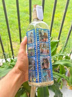 someone holding up a bottle with pictures on it