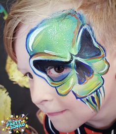 a young boy with his face painted like a butterfly