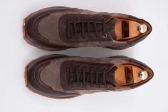 a pair of brown shoes on top of a white surface