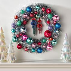 a christmas wreath with ornaments hanging on the wall