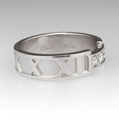 a white gold wedding ring with diamonds on the side and an x pattern in the middle