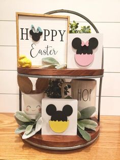 a wooden shelf with some mickey mouse coasters on top of it and a sign that says happy easter