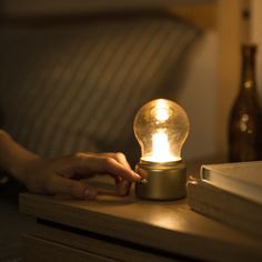 a light bulb sitting on top of a table next to a book and glass bottle