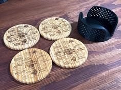 four wooden coasters sitting on top of a wooden table next to a grater