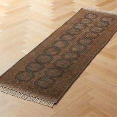 a brown and black rug sitting on top of a wooden floor next to a hard wood floor