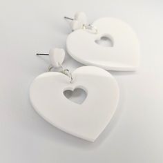 This classic double heart trapeze design has been given a retro feel with a simple white acrylic, they are lightweight and so stylish, perfect for any occasion. All orders are packaged with care. Each box includes tissue paper, a tealight and a KelZo postcard. Product details: Acrylic Approx 5.8cm Hypoallergenic stainless steel studs ****Colours may vary slightly from image due to resolution differences. Colour patterns may not match photographed item but will be cut from same piece/collection. Shapes and sizes may also vary due to the nature of handmade products.*** Care and Returns Please handle your KelZo Jewellery with care, as it is handmade and more fragile compared to mass market jewellery. Returns/replacements on pierced items are not accepted unless faulty, due to hygiene reasons. Trendy White Heart-shaped Earrings, White Double Heart Classic Jewelry, Classic White Double Heart Jewelry, Everyday White Heart Earrings, Trendy White Plastic Earrings, Trendy White Earrings, White Double Heart Earrings For Gift, Classic White Heart Earrings For Gift, White Heart Earrings For Valentine's Day