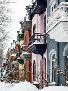 a row of multi - colored houses covered in snow