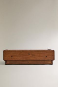 a wooden shelf sitting on top of a white wall