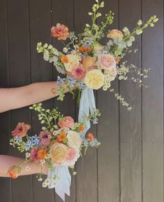 a bouquet of flowers is being held by someone's hand