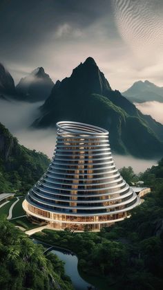 an aerial view of a building in the middle of mountains with fog rolling over it