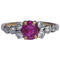 The central ruby in this ring is absolutely stunning. It is bright pink in colour and measures approx 60pts and either side of it are four smaller diamonds each measuring 5pts each. The stones are set in platinum and the rest of the ring is modelled in 18ct gold. Ring Size: N 1/2 or 7 Width: 6mm Height From Finger: 4.5mm Weight: 2.6g Vintage Ruby Ring, Ruby Diamond, Rings Simple, Blue Diamond, Color Rosa, Bright Pink, Gold Ring, Heart Ring, Cuff Bracelets