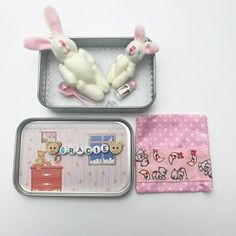 two small tins with stuffed animals in them