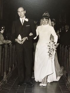 an old black and white photo of a bride and groom walking down the aisle together